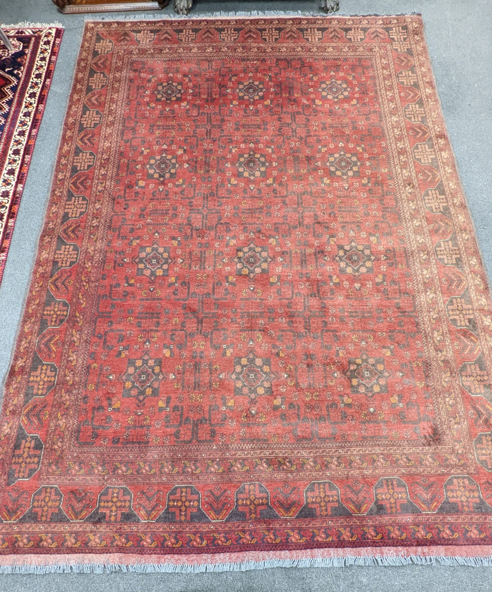 An Afghan red ground carpet, 300 x 208cm